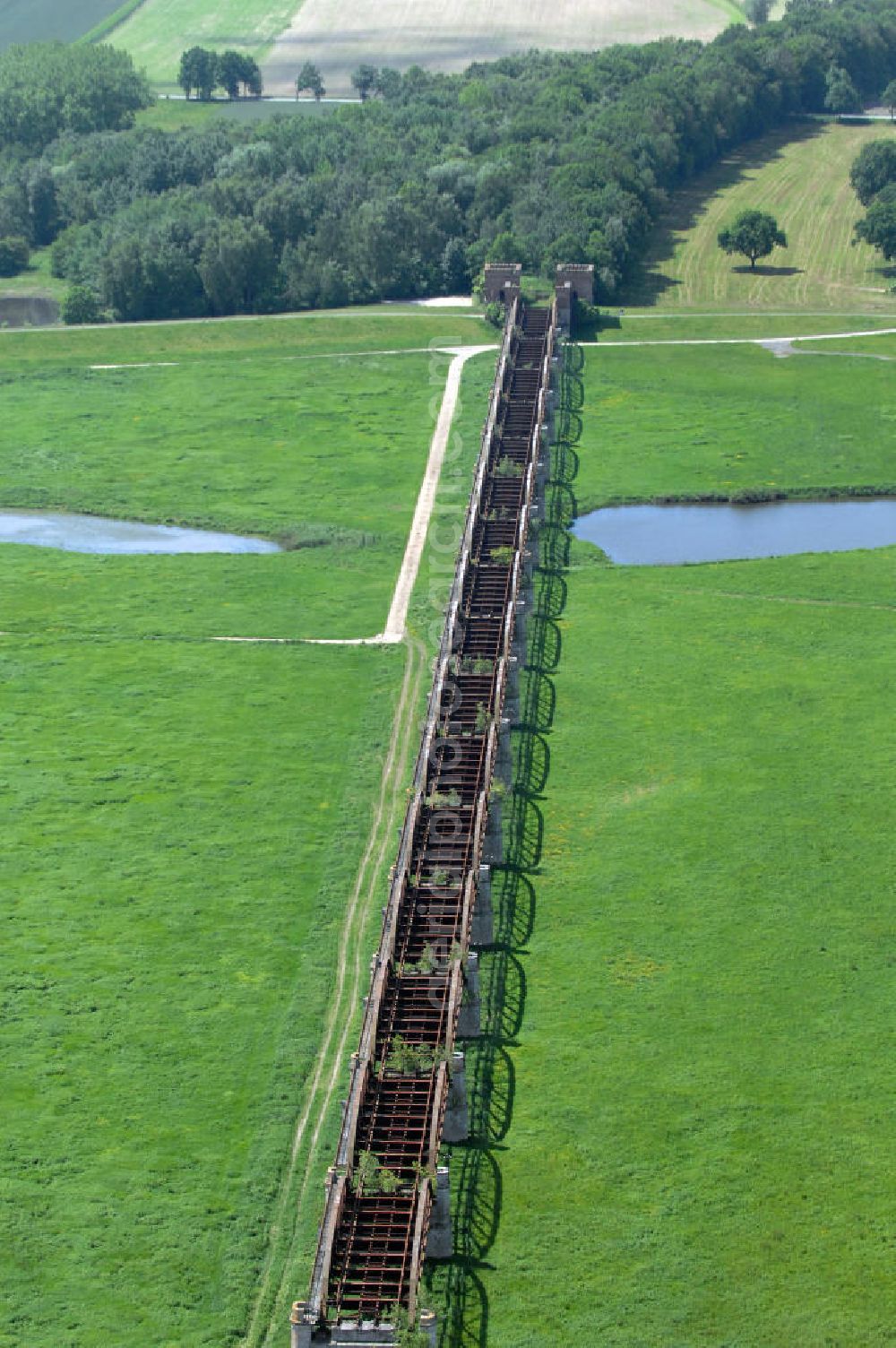 Aerial image Dömitz - Ruine der Eisenbahnbrücke Dömitz, sie wurde in den Jahren 1870–1873 für die Wendlandbahn errichtet und bis zum Zweiten Weltkrieg befahren.An jedem Brückenende befand sich ein wehrhaft ausgebautes Brückenhaus. Starke Türme mit Zinnenkranz und Schießscharten standen beiderseits der Gleise. Im Erdgeschoss und Fundamentbereich lagen Gewölbe in kasemattenähnlicher Form. Der erste Spatenstich zum Bau der Brücke wurde am 08.09.1870 ausgeführt. Die Brücke hatte eine Gesamtlänge von 1.050 Metern. Nach ihrer Zerstörung am 20. April 1945 erfolgte kein Wiederaufbau, da die Elbe hier Teil der innerdeutschen Grenze war.