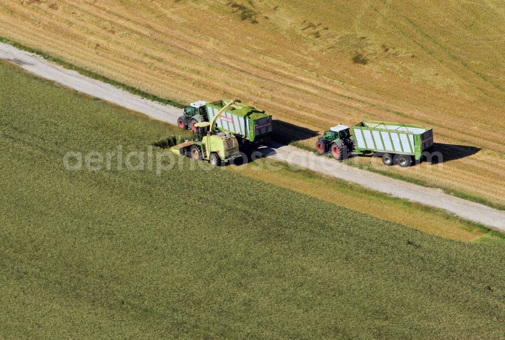 Aerial photograph Kranichfeld - Combines during the harvest of an agricultural fiel in Thuringia