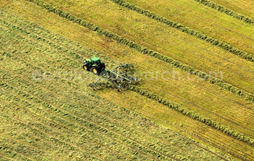 Aerial photograph Osthausen - Combines during the harvest of an agricultural field near Osthausen in Thuringia