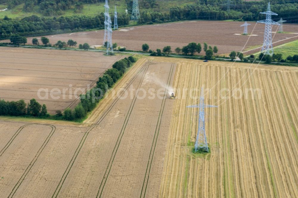 Aerial image Agathenburg - Harvest use of heavy agricultural machinery - combine harvesters and harvesting vehicles on agricultural fields in Agathenburg in the state Lower Saxony, Germany