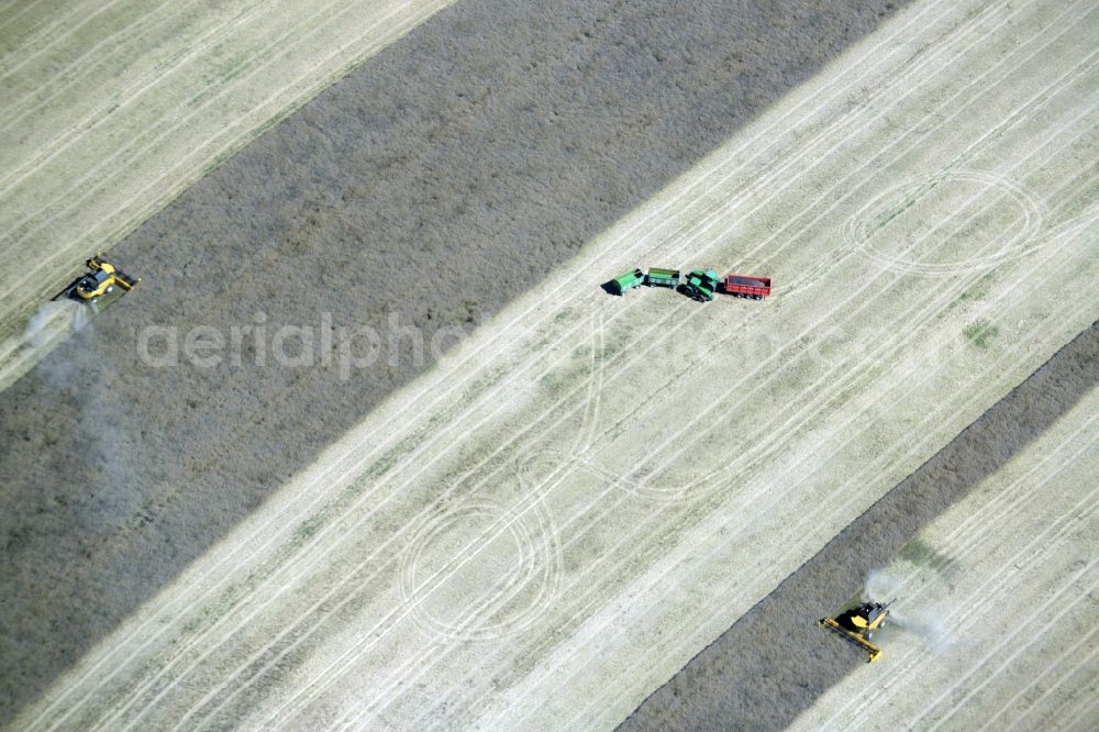 Aerial image Diekhof - Harvest use of heavy agricultural machinery - combine harvesters and harvesting vehicles on agricultural fields in Diekhof in the state Mecklenburg - Western Pomerania