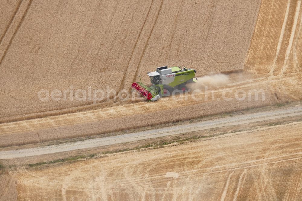 Dransfeld from above - Harvest use of heavy agricultural machinery - combine harvesters and harvesting vehicles on agricultural fields in Dransfeld in the state Lower Saxony, Germany