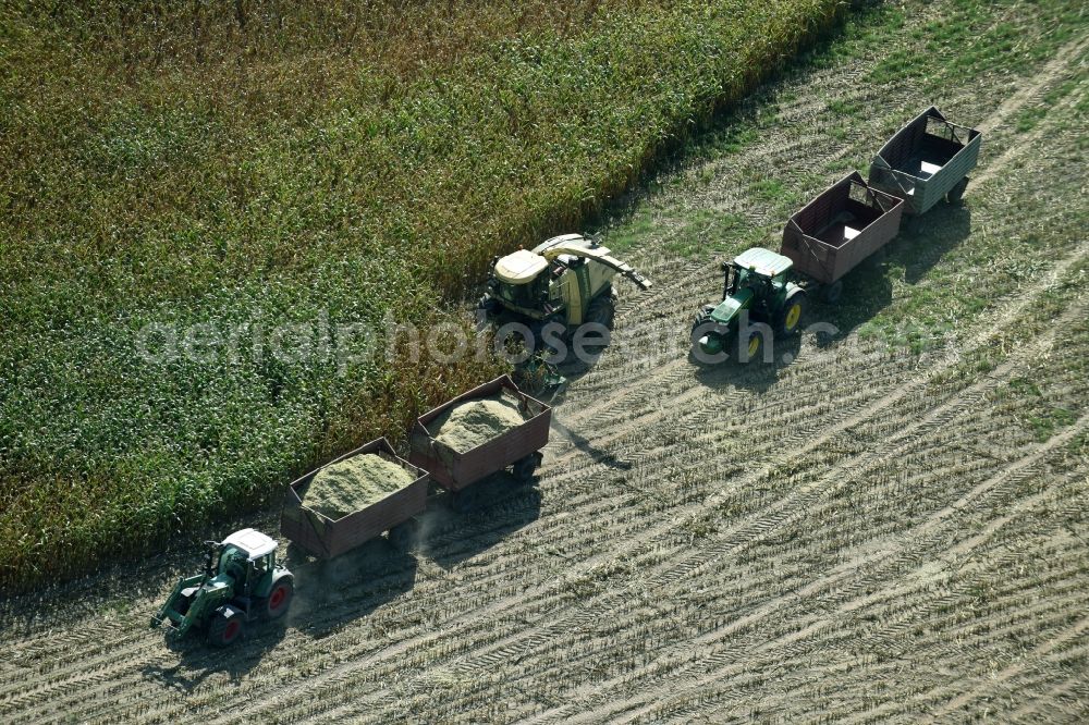 Aerial photograph Käthen - Harvest use of heavy agricultural machinery - combine harvesters and harvesting vehicles on agricultural fields in Kaethen in the state Saxony-Anhalt