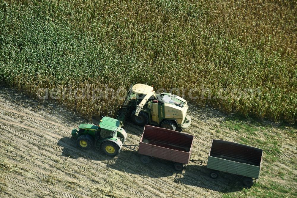 Aerial photograph Käthen - Harvest use of heavy agricultural machinery - combine harvesters and harvesting vehicles on agricultural fields in Kaethen in the state Saxony-Anhalt