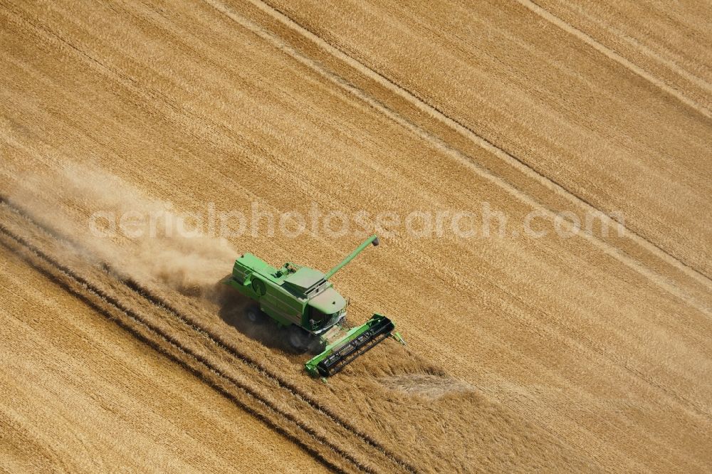 Rosdorf from above - Harvest use of heavy agricultural machinery - combine harvesters and harvesting vehicles on agricultural fields in Rosdorf in the state Lower Saxony