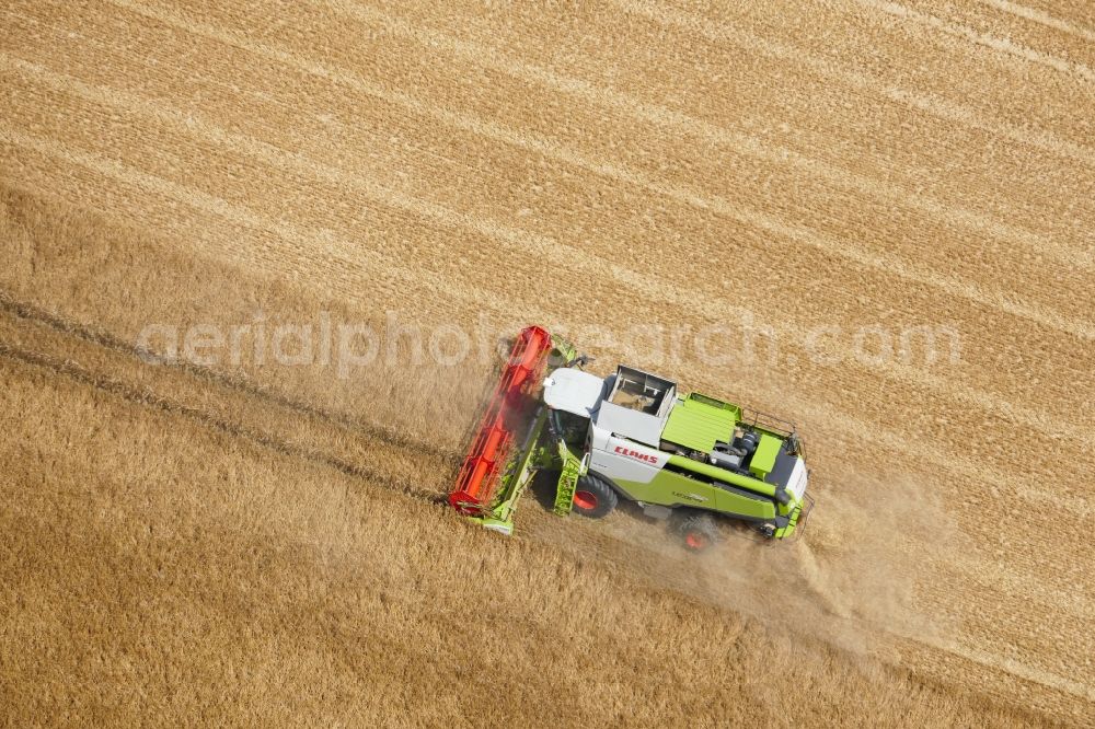 Rosdorf from the bird's eye view: Harvest use of heavy agricultural machinery - combine harvesters and harvesting vehicles on agricultural fields in Rosdorf in the state Lower Saxony