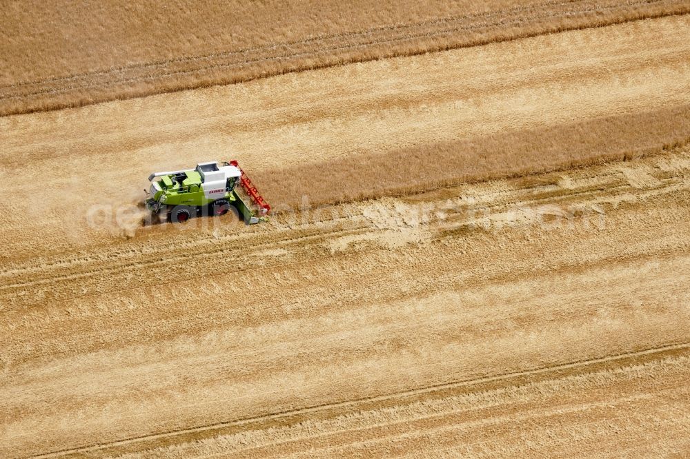 Rosdorf from the bird's eye view: Harvest use of heavy agricultural machinery - combine harvesters and harvesting vehicles on agricultural fields in Rosdorf in the state Lower Saxony, Germany