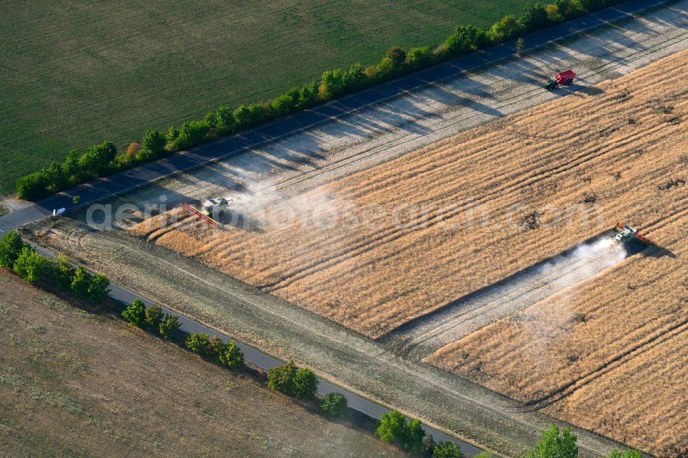 Aerial photograph Wüllersleben - Harvest use of heavy agricultural machinery - combine harvesters and harvesting vehicles on agricultural fields in Wuellersleben in the state Thuringia, Germany