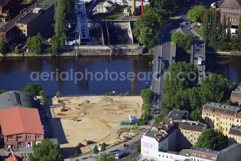 Berlin from above - Construction site at the Stubenrauch Bridge in the Schöneweide part of the district of Treptow - Köpernick in Berlin. The industrial wasteland is located on Siemensstraße on the bank of the river Spree. The adjacent industrial buildings are listed as monuments. On the opposite riverbank lies the heating plant Schöneweide, one of two core facilities in the district heating system