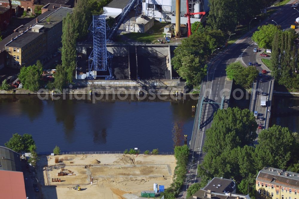 Berlin from the bird's eye view: Construction site at the Stubenrauch Bridge in the Schöneweide part of the district of Treptow - Köpernick in Berlin. The industrial wasteland is located on Siemensstraße on the bank of the river Spree. The adjacent industrial buildings are listed as monuments. On the opposite riverbank lies the heating plant Schöneweide, one of two core facilities in the district heating system