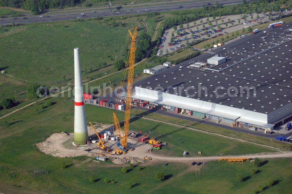 Aerial image Berlin - Blick auf das Erste Windrad Berlins im Gewerbegebiet Pankow Berlin. Nach Klagen des Naturschutzbundes NABU wurde der Bau des ersten Windkraftrads im April 2008 bewilligt. Es soll eine Höhe von 180 Metern betragen und ist mit einer Leistung von zwei Megawatt in der Lage ca. 1000 Vier - Personen - Haushalte für ein Jahr zu versorgen. Aufgrund eines neuen Erneuerbare - Energien - Gesetz (EEG) wird die Anlage erst mit in Kraft treten des Gesetzen im Januar 2009 in Betrieb genommen. Das Rad ist eine von Enercon gebaute E82. Kontakt Enercon: ENERCON GmbH, Dreekamp 5, 26605 Aurich, Tel. +49(0)4941 927 0, Fax +49(0)4941 927 109, Email: info@enercon.de