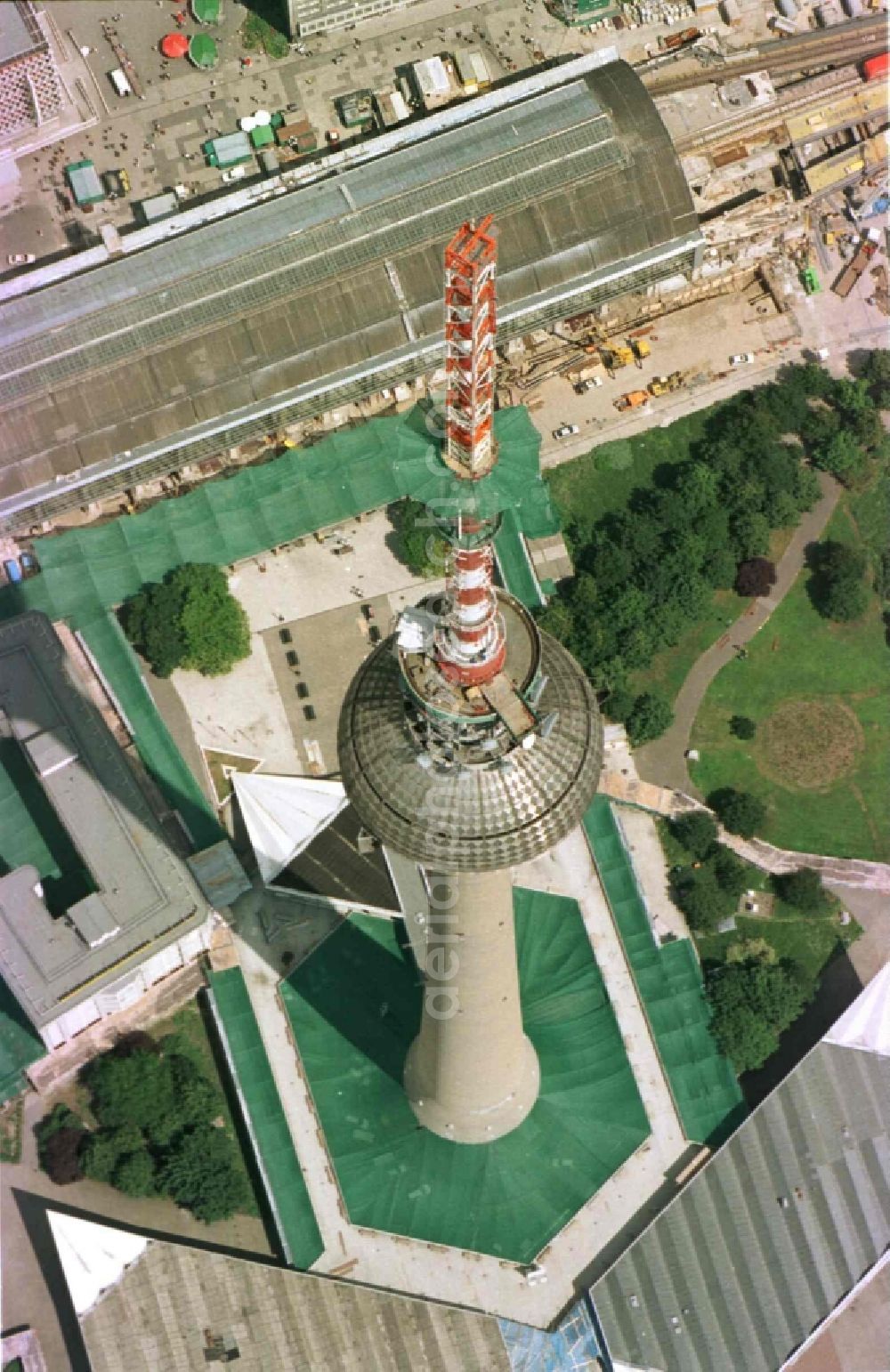 Aerial image Berlin - Extension construction site to raise the steel mast antenna support above the shiny silver sphere of the telecommunications tower building and television tower in Mitte in Berlin, Germany