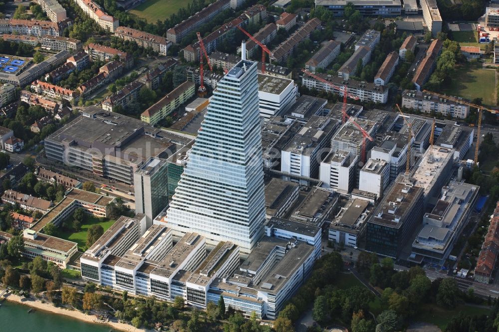 Basel from the bird's eye view: Extension construction sites on the premises and premises of the pharmaceutical company Roche with the cityscape-defining high-rise in Basel in Switzerland