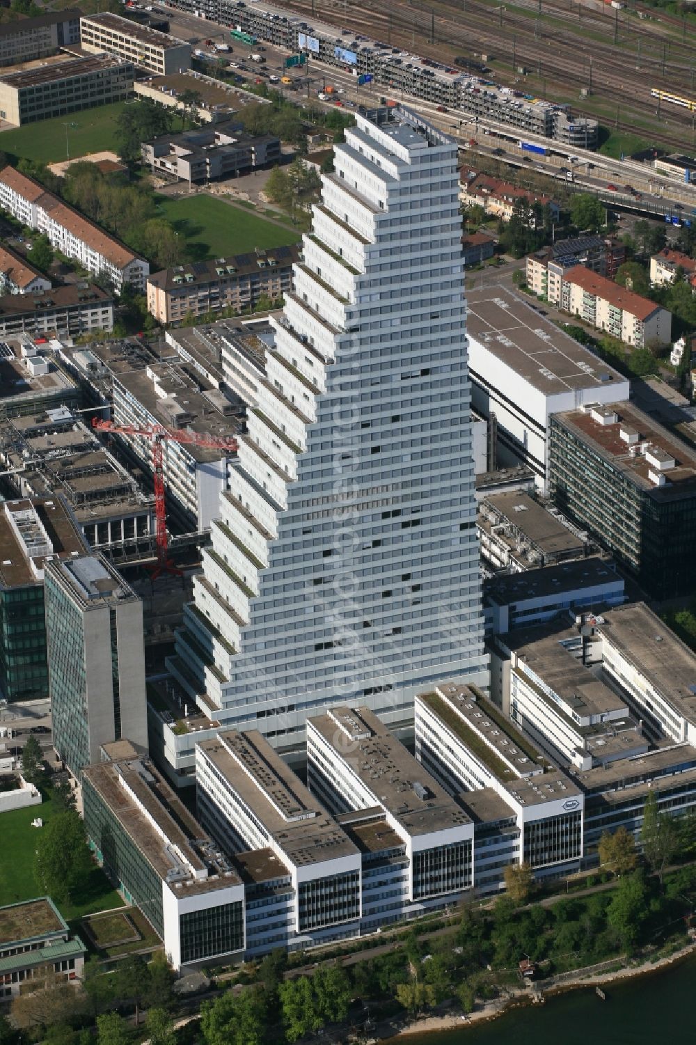 Basel from the bird's eye view: Extension construction sites on the premises and premises of the pharmaceutical company Roche with the cityscape-defining high-rise in Basel in Switzerland