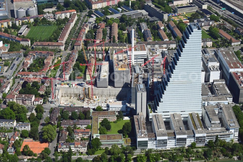 Basel from the bird's eye view: Extension construction sites on the premises and premises of the pharmaceutical company Roche with the cityscape-defining high-rise in Basel in Switzerland