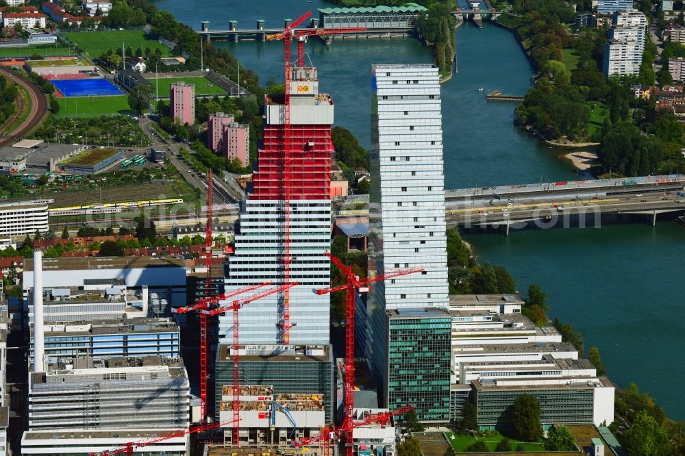 Aerial image Basel - Extension construction sites on the premises of the pharmaceutical company Roche with the cityscape-defining high-rise building in Basel in Switzerland. Construction works for the second tower are visible