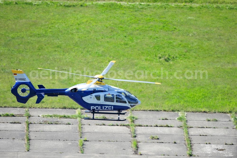 Werneuchen from the bird's eye view: View one just above the runway / runway of the airfield Werneuchen floating Eurocopter with the registration D-HBBZ the Federal Police