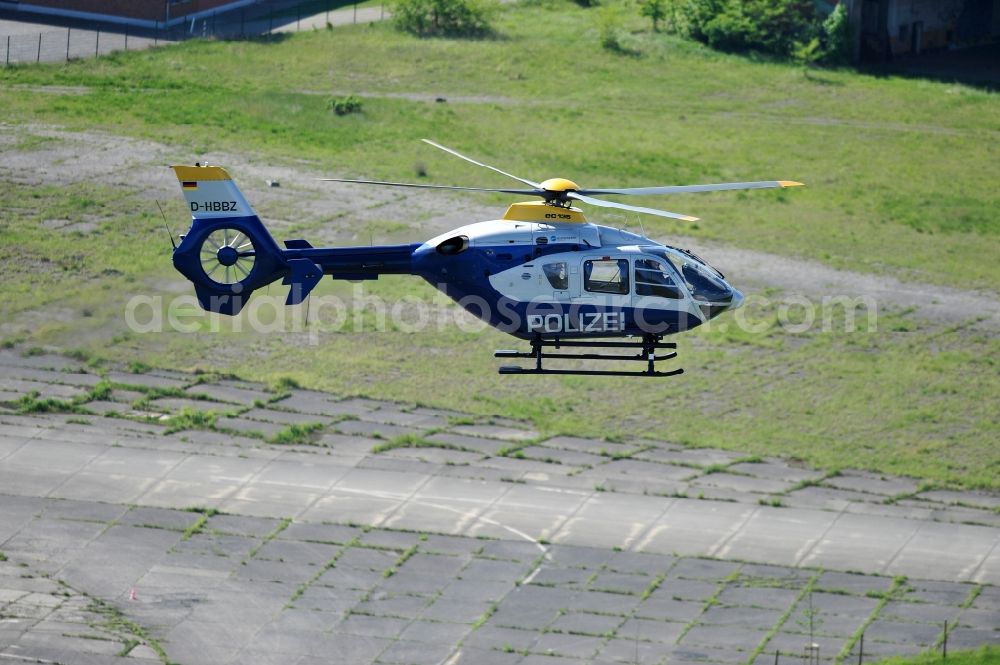 Werneuchen from the bird's eye view: View one just above the runway / runway of the airfield Werneuchen floating Eurocopter with the registration D-HBBZ the Federal Police