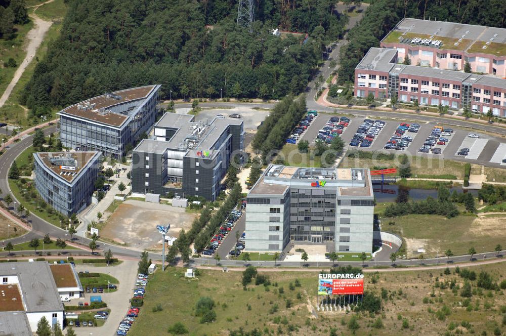 Kleinmachnow from the bird's eye view: Blick auf den Europarc nahe der Waldsiedlung Dreilinden bei Kleinmachnow. Dreilinden ist die Bezeichnung eines Forstes und einer Kolonie bekannt für die Grenzübergangsstelle Drewitz. Der Europarc ist ein Gewerbepark auf dem ehemaligen Gelände der wichtigsten Transitstrecke nach Westen und Süden (Checkpoint Bravo). Bekannt sind hier unter an derem eBay Deutschland, mobile.de und Harley-Davidson sowie weitere kleinere Firmen und zwei Hotels. Die Arbeiten begannen 1990 und bis heute ist der Park bei weitem nicht ausgelastet. Weitere Europarcs gibt es in Frankreich und Spanien. Kontakt: Europarc GmbH, Albert-Einstein-Ring 1, 14532 Kleinmachnow / Dreilinden, Walter Brümmer, Tel.: 030/21733100.