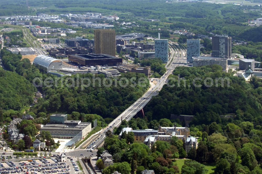 Luxemburg from the bird's eye view: Blick auf den Kreisverkehr Robert Schuman im Vordergrund und den von ihm abgehenden Boulevard Robert Schuman, die N51, der über die Brücke Grand-Duchesse Charlotte (auf Deutsch: Grossherzogin-Charlotte-Brücke) führt. Die Brücke stammt vom deutschen Architekten Egon Jux und wurde 1965 fertig gestellt. Dahinter ist das europäische Viertel zu sehen mit dem Cour de justice des Communautes europeennes auf der linken Seite (der europäische Gerichtshof). Die N51 wird hier zur Avenue John Fitzgerald Kennedy. Das Europaviertel in Luxemburg befindet sich auf dem Kirchberg - Plateau. Im Vordergrund ist der Parkplatz Glacis zu sehen.