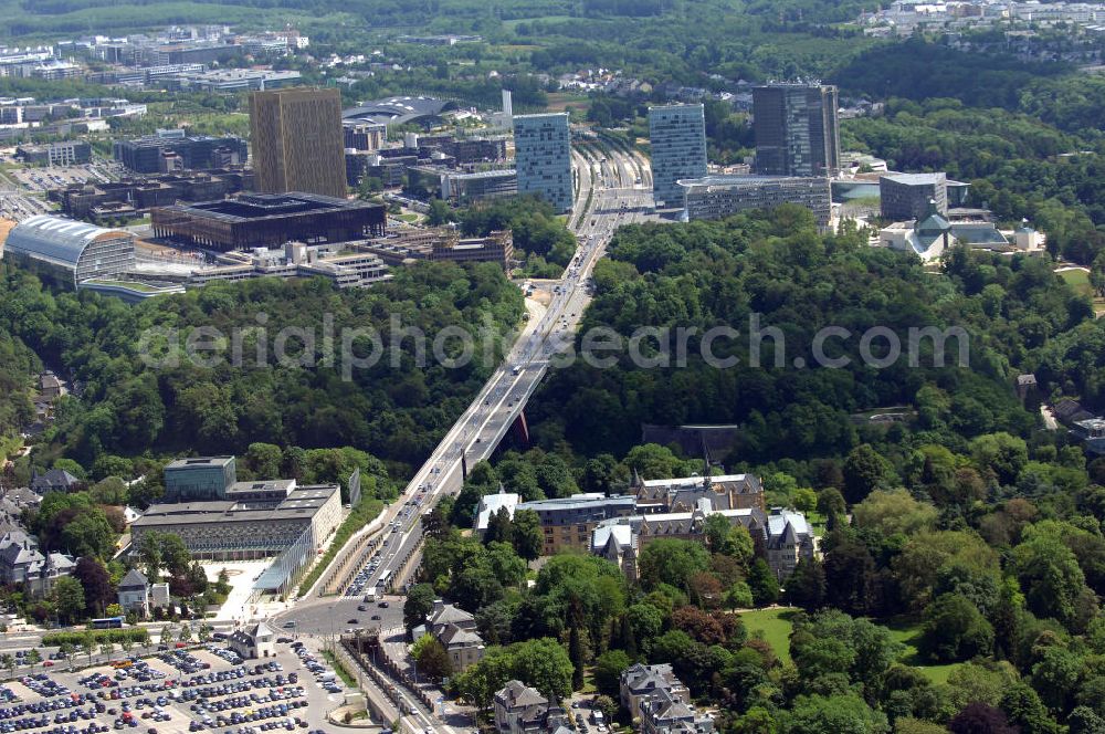 Aerial photograph Luxemburg - Blick auf den Kreisverkehr Robert Schuman im Vordergrund und den von ihm abgehenden Boulevard Robert Schuman, die N51, der über die Brücke Grand-Duchesse Charlotte (auf Deutsch: Grossherzogin-Charlotte-Brücke) führt. Die Brücke stammt vom deutschen Architekten Egon Jux und wurde 1965 fertig gestellt. Dahinter ist das europäische Viertel zu sehen mit dem Cour de justice des Communautes europeennes auf der linken Seite (der europäische Gerichtshof). Die N51 wird hier zur Avenue John Fitzgerald Kennedy. Das Europaviertel in Luxemburg befindet sich auf dem Kirchberg - Plateau. Im Vordergrund ist der Parkplatz Glacis zu sehen.