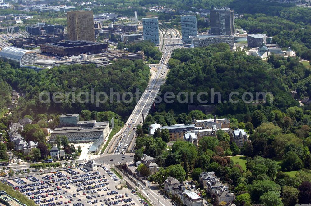 Luxemburg from above - Blick auf den Kreisverkehr Robert Schuman im Vordergrund und den von ihm abgehenden Boulevard Robert Schuman, die N51, der über die Brücke Grand-Duchesse Charlotte (auf Deutsch: Grossherzogin-Charlotte-Brücke) führt. Die Brücke stammt vom deutschen Architekten Egon Jux und wurde 1965 fertig gestellt. Dahinter ist das europäische Viertel zu sehen mit dem Cour de justice des Communautes europeennes auf der linken Seite (der europäische Gerichtshof). Die N51 wird hier zur Avenue John Fitzgerald Kennedy. Das Europaviertel in Luxemburg befindet sich auf dem Kirchberg - Plateau. Im Vordergrund ist der Parkplatz Glacis zu sehen.