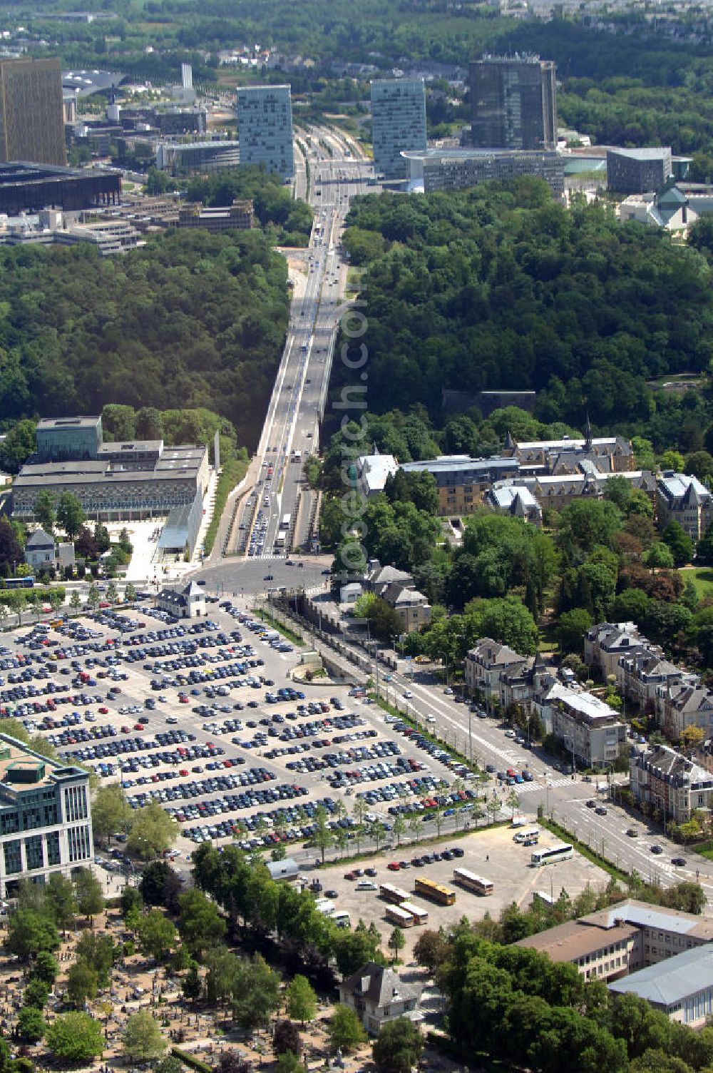 Luxemburg from the bird's eye view: Blick auf den Kreisverkehr Robert Schuman im Vordergrund und den von ihm abgehenden Boulevard Robert Schuman, die N51, der über die Brücke Grand-Duchesse Charlotte (auf Deutsch: Grossherzogin-Charlotte-Brücke) führt. Die Brücke stammt vom deutschen Architekten Egon Jux und wurde 1965 fertig gestellt. Dahinter ist das europäische Viertel zu sehen mit dem Cour de justice des Communautes europeennes auf der linken Seite (der europäische Gerichtshof). Die N51 wird hier zur Avenue John Fitzgerald Kennedy. Das Europaviertel in Luxemburg befindet sich auf dem Kirchberg - Plateau. Im Vordergrund ist der Parkplatz Glacis zu sehen.