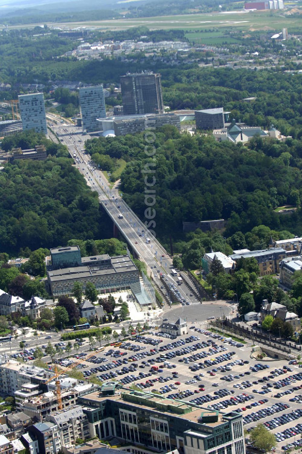 Aerial photograph Luxemburg - Blick auf den Kreisverkehr Robert Schuman im Vordergrund und den von ihm abgehenden Boulevard Robert Schuman, die N51, der über die Brücke Grand-Duchesse Charlotte (auf Deutsch: Grossherzogin-Charlotte-Brücke) führt. Die Brücke stammt vom deutschen Architekten Egon Jux und wurde 1965 fertig gestellt. Dahinter ist das europäische Viertel zu sehen mit dem Cour de justice des Communautes europeennes auf der linken Seite (der europäische Gerichtshof). Die N51 wird hier zur Avenue John Fitzgerald Kennedy. Das Europaviertel in Luxemburg befindet sich auf dem Kirchberg - Plateau. Im Vordergrund ist der Parkplatz Glacis zu sehen.