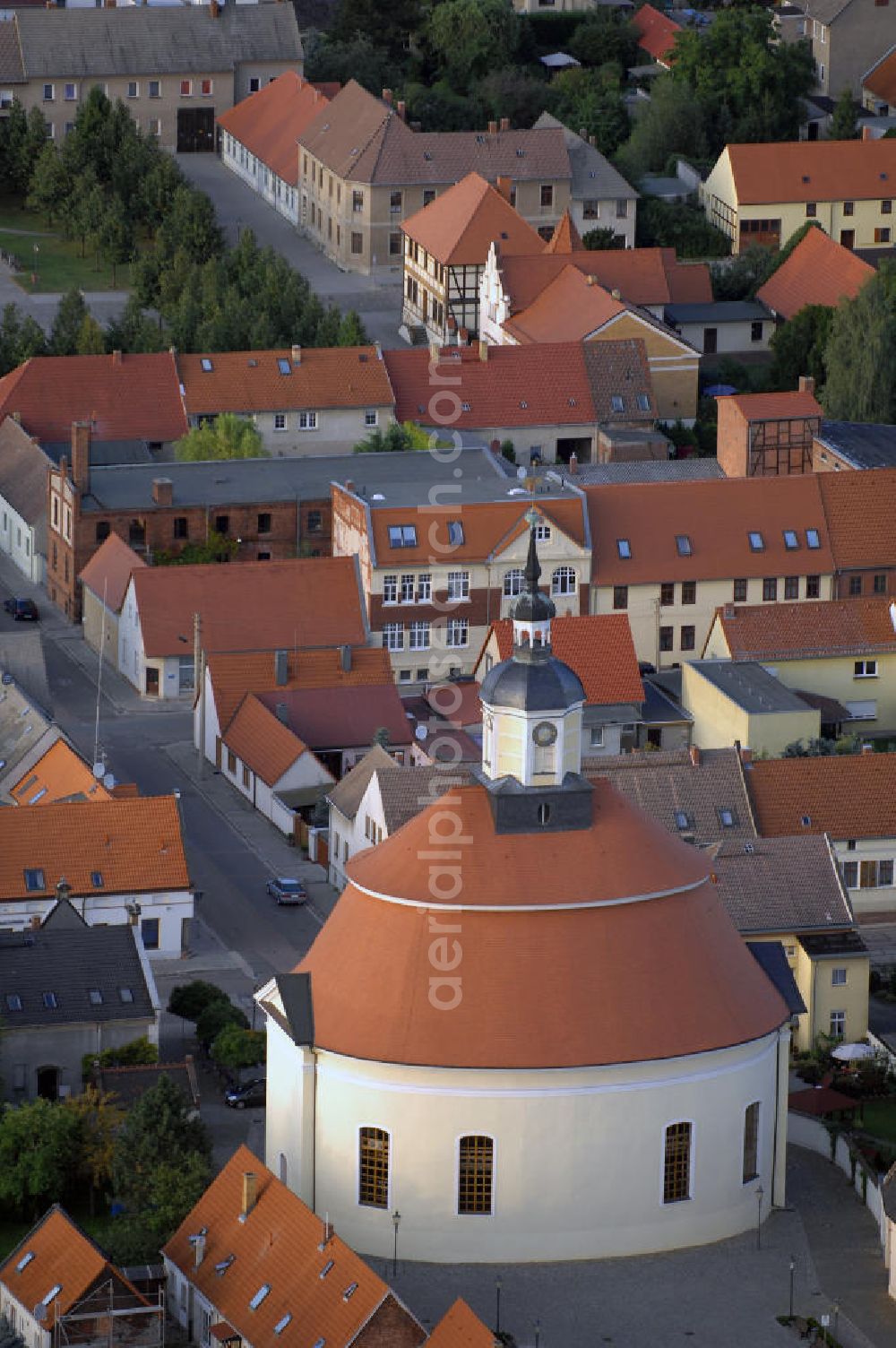 Oranienbaum from above - Blick auf die Evangelische Stadtkirche Oranienbaum in Sachsen - Anhalt. Die Kirche wurde im Stil des Barock erbaut und im Jahr 1712 eingeweiht. Mit ihrerm ungewöhnlich elliptischen Grundriss ist sie ein beliebtes Ausflugsziel für Touristen. Trotz ihrer Restaurierung in den Jahren von 1991 bis 1995 macht die Kirche noch den Eindruck eines im Original erhaltenen Bauwerks. Kontakt Pfarramt: Evangelisches Pfarramt Oranienbaum, Brauerstraße 26, 06785 Oranienbaum, Tel. +49(0)34904 20512, Fax +49(0)34904 21742, Email: stadtkirche-oranienbaum@kircheanhalt.de; Kontakt Touristinfo: Stadtinformation Oranienbaum, Schloßstraße 17, 06785 Oranienbaum, Tel. +49(0)34904 22520