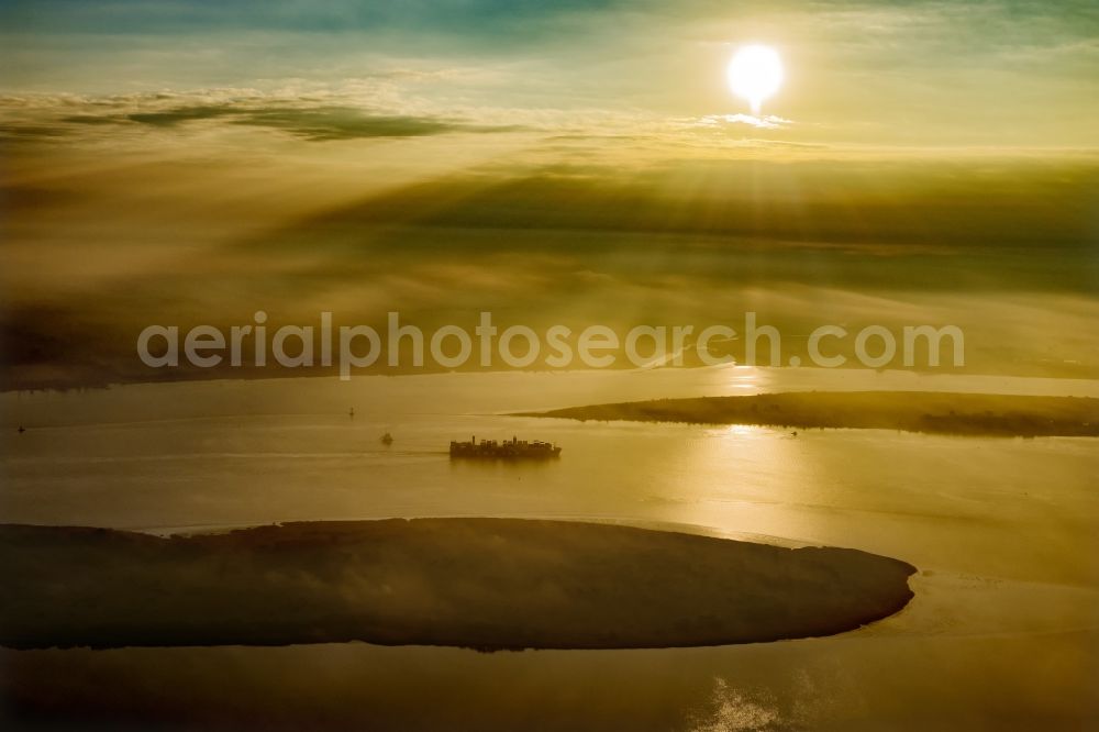 Drochtersen from above - Sailing container ship auf of Elbe in Sonnenaufgang in Drochtersen in the state Lower Saxony, Germany