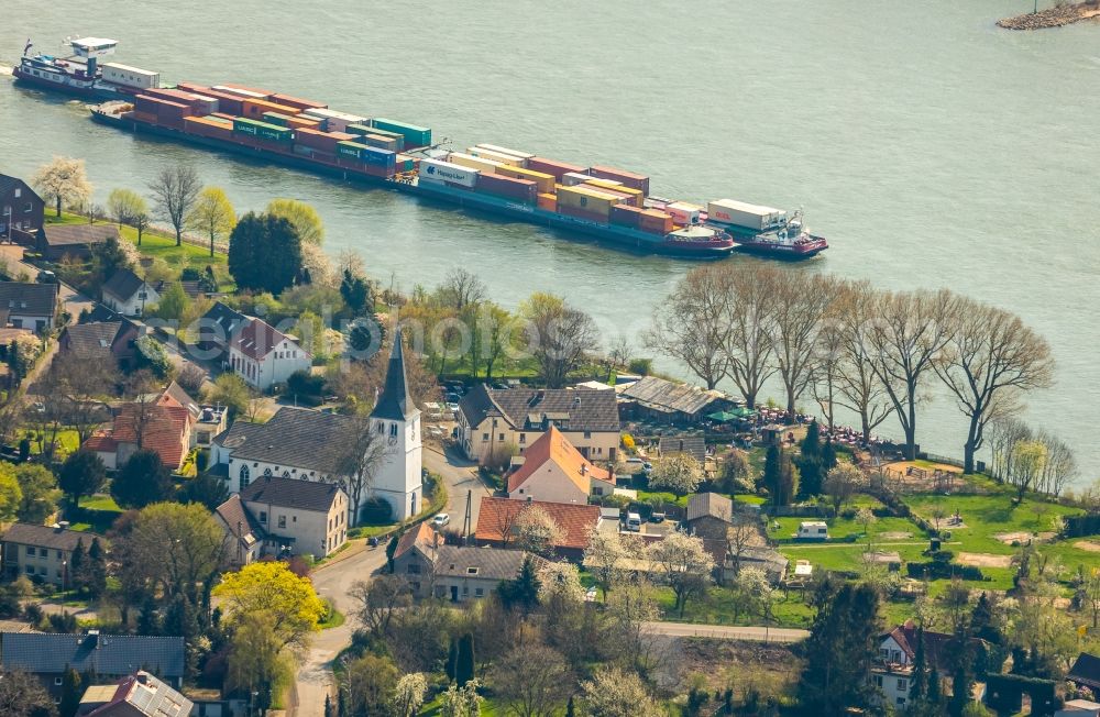 Voerde (Niederrhein) from the bird's eye view: Sailing container ship on the river course of the Rhine in Voerde (Niederrhein) in the state North Rhine-Westphalia, Germany