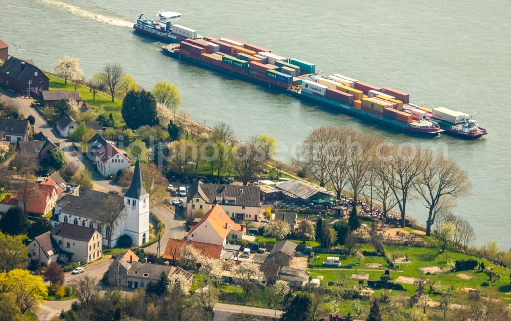 Aerial image Voerde (Niederrhein) - Sailing container ship on the river course of the Rhine in Voerde (Niederrhein) in the state North Rhine-Westphalia, Germany