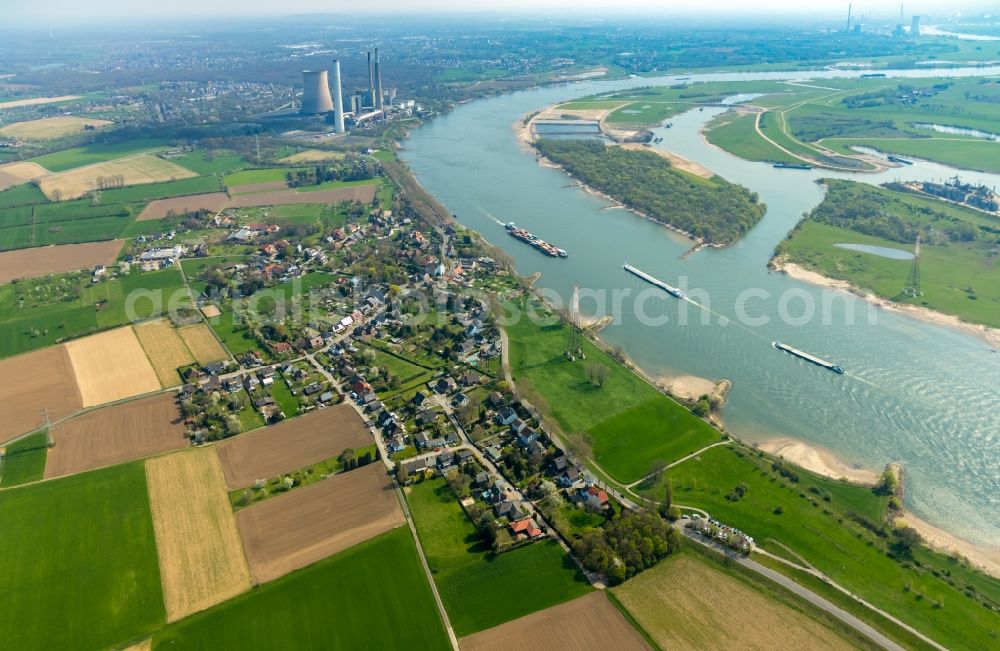 Aerial photograph Voerde (Niederrhein) - Sailing container ship on the river course of the Rhine in Voerde (Niederrhein) in the state North Rhine-Westphalia, Germany