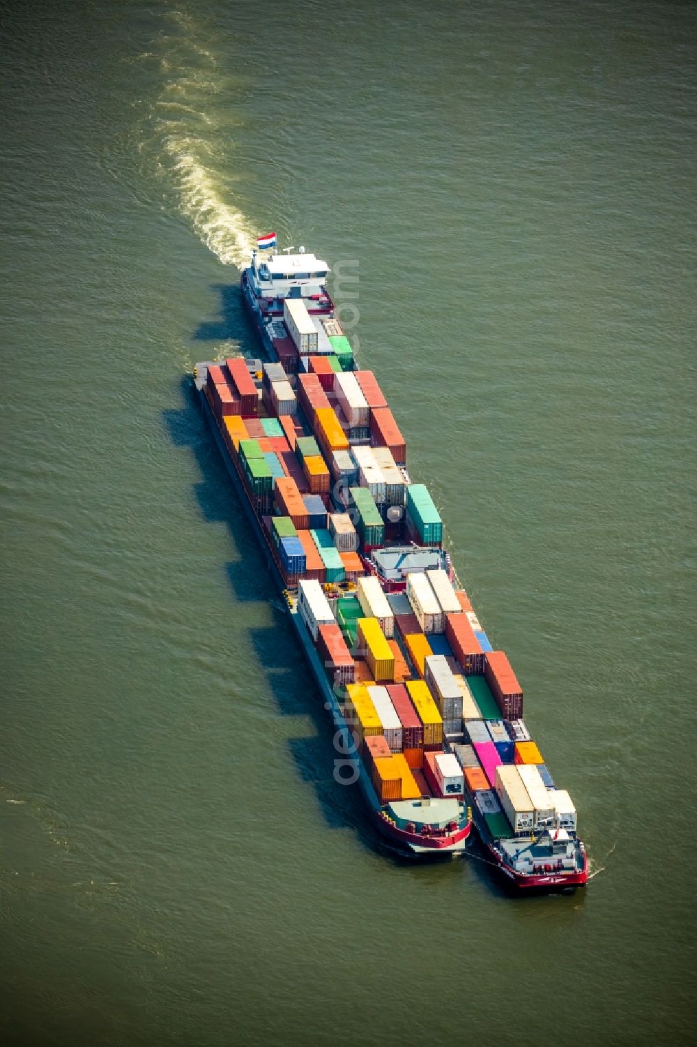 Voerde (Niederrhein) from above - Sailing container ship on the river course of the Rhine in Voerde (Niederrhein) in the state North Rhine-Westphalia, Germany