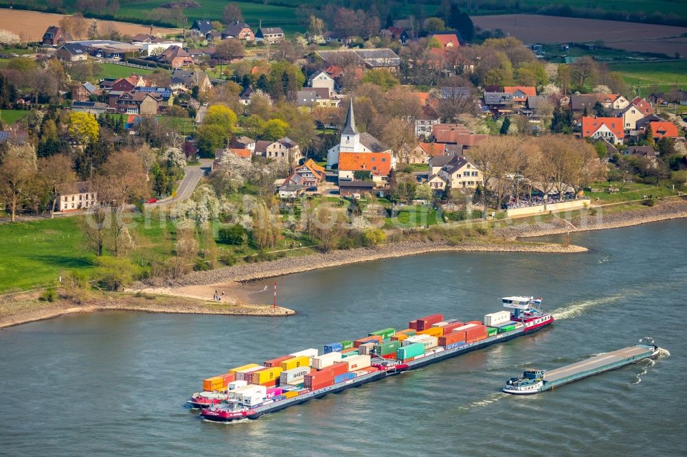 Aerial photograph Voerde (Niederrhein) - Sailing container ship on the river course of the Rhine in Voerde (Niederrhein) in the state North Rhine-Westphalia, Germany