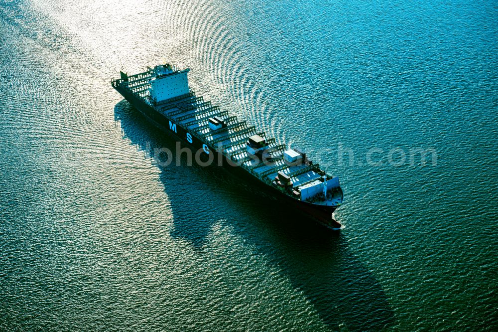 Brunsbüttel from the bird's eye view: Sailing container ship MSC Tokyo Monrovia on street Zum Elbdeich in Brunsbuettel in the state Schleswig-Holstein, Germany