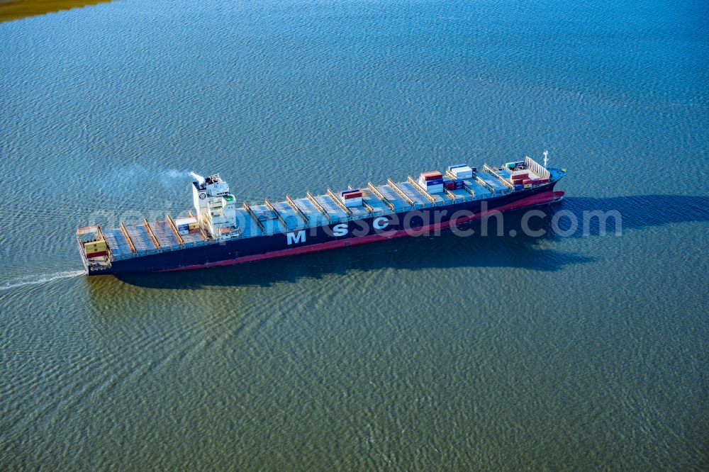 Aerial image Brunsbüttel - Sailing container ship MSC Tokyo Monrovia on street Zum Elbdeich in Brunsbuettel in the state Schleswig-Holstein, Germany