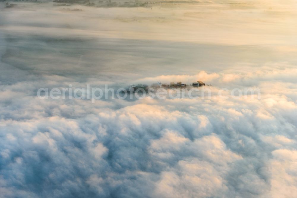 Hetlingen from above - Sailing container ship on the river Elbe covered in fog in Hetlingen in the state Schleswig-Holstein, Germany