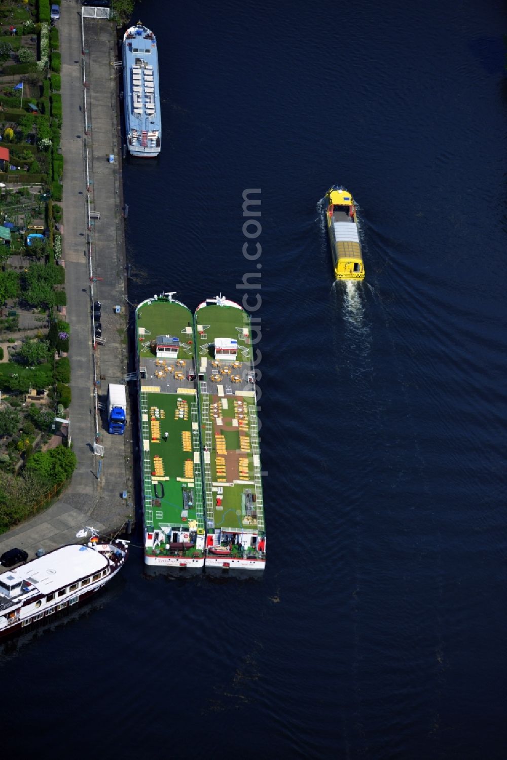 Aerial photograph Potsdam - In port on the Long Bridge in the city center of Potsdam in Brandenburg passenger ships are moored. The White Fleet Potsdam GmbH starts with their steamers from here in the lakes around the state capital. A water taxi passes through the port area