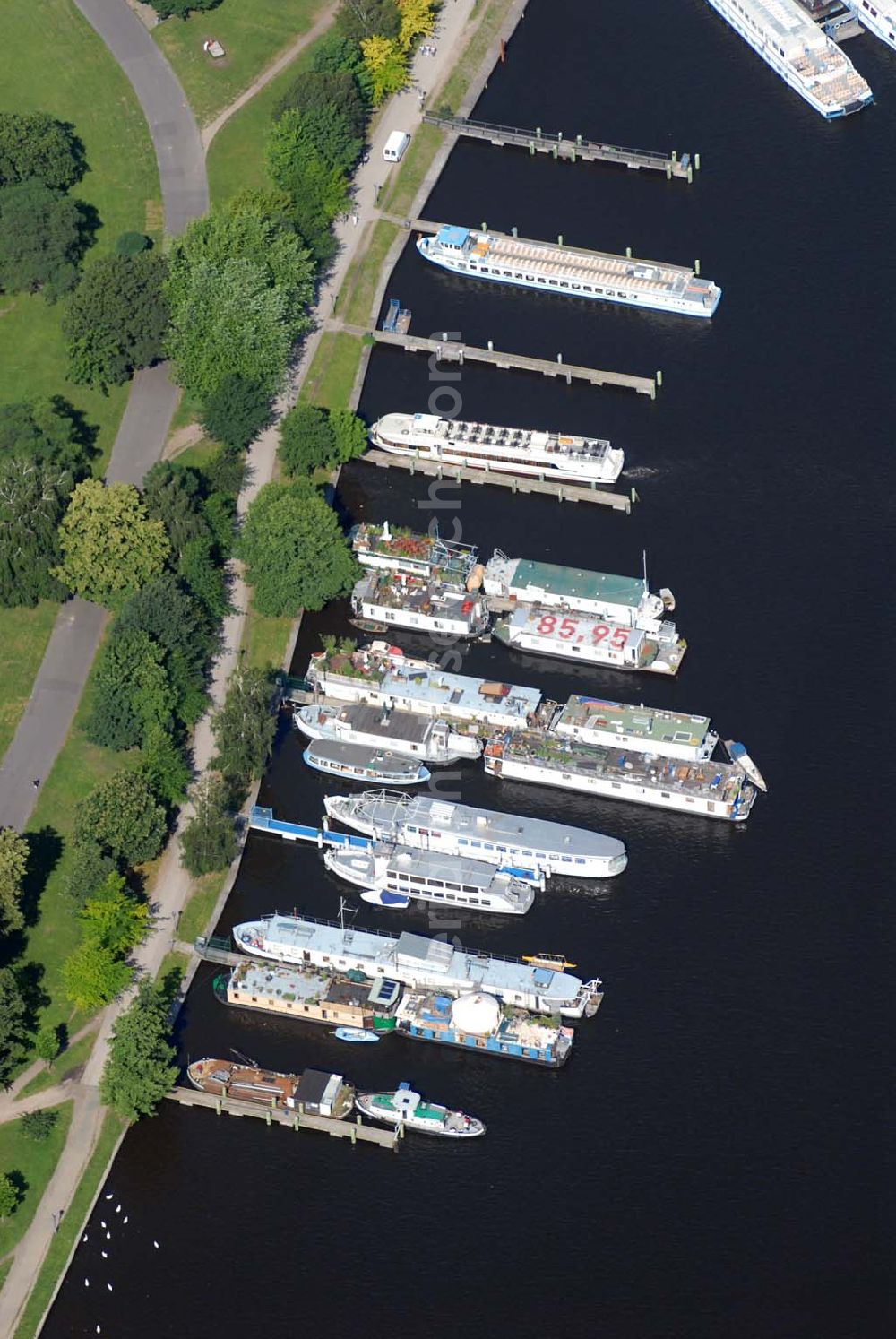 Aerial photograph Berlin - Blick auf den Fahrgastschiffhafen Treptow. Die Stern und Kreisschiffahrt GmbH Berlin ist ein Berliner Schifffahrtunternehmen mit Sitz in Alt-Treptow. Das Unternehmen wurde am 8. August 1888 vom Kaufmann Krokisius aus der Berliner und Stralauer Dampfschiffahrts-Gesellschaft unter dem Namen Spree-Havel-Dampfschiffahrts-Gesellschaft Stern gegründet und fusionierte 1992 mit der Weißen Flotte Berlin. Es betreibt mit heute 30 Fahrgastschiffen den Fähr- und Ausflugsverkehr in und um Berlin und gehört zur Hegemann-Gruppe.