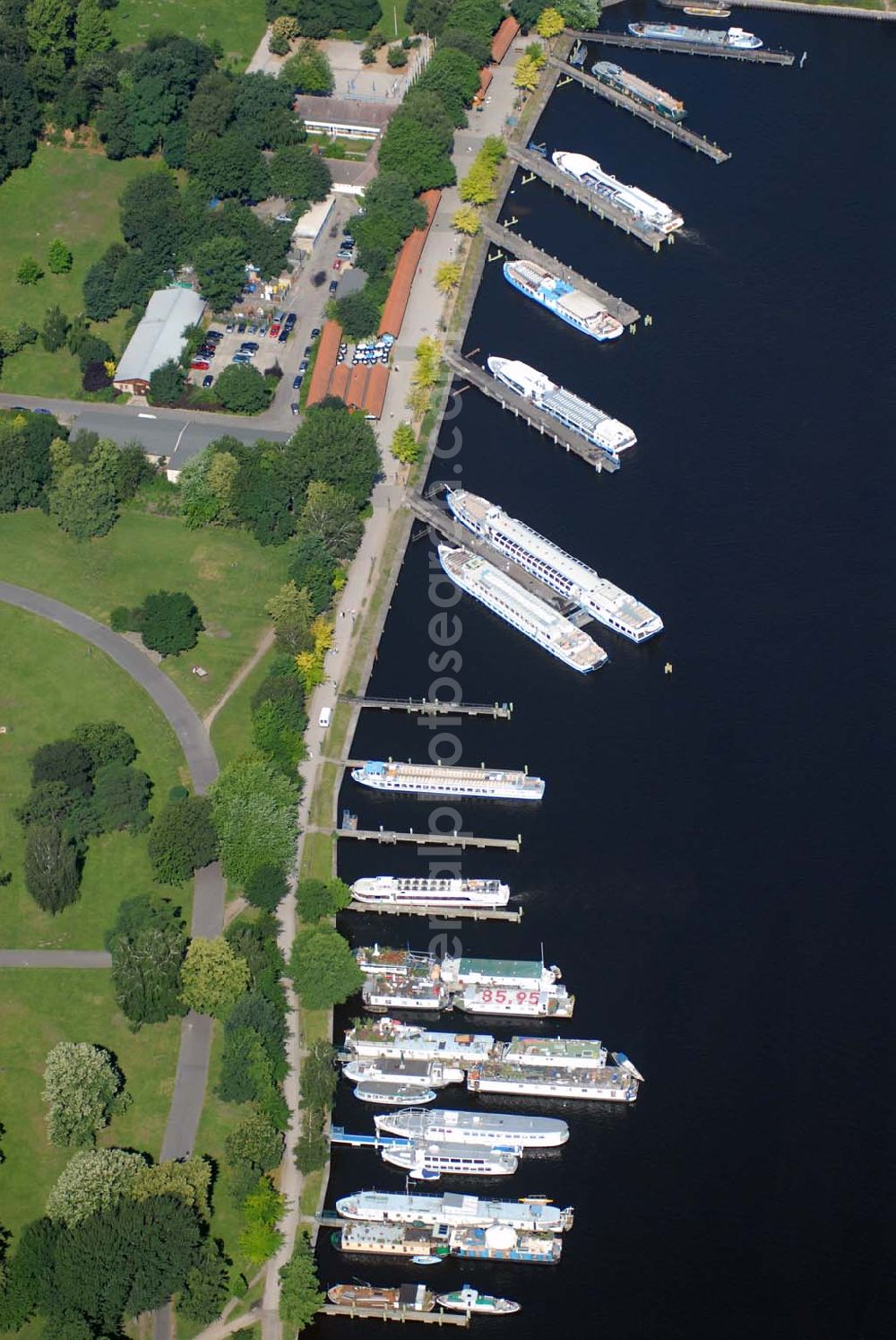 Berlin from above - Blick auf den Fahrgastschiffhafen Treptow. Die Stern und Kreisschiffahrt GmbH Berlin ist ein Berliner Schifffahrtunternehmen mit Sitz in Alt-Treptow. Das Unternehmen wurde am 8. August 1888 vom Kaufmann Krokisius aus der Berliner und Stralauer Dampfschiffahrts-Gesellschaft unter dem Namen Spree-Havel-Dampfschiffahrts-Gesellschaft Stern gegründet und fusionierte 1992 mit der Weißen Flotte Berlin. Es betreibt mit heute 30 Fahrgastschiffen den Fähr- und Ausflugsverkehr in und um Berlin und gehört zur Hegemann-Gruppe.