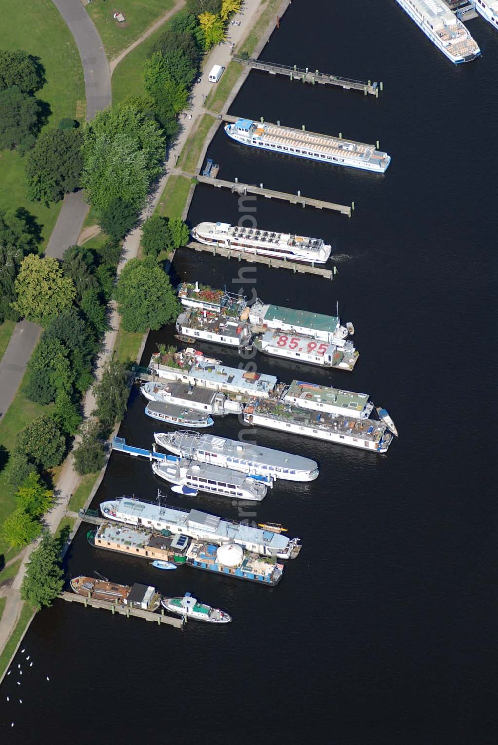 Aerial image Berlin - Blick auf den Fahrgastschiffhafen Treptow. Die Stern und Kreisschiffahrt GmbH Berlin ist ein Berliner Schifffahrtunternehmen mit Sitz in Alt-Treptow. Das Unternehmen wurde am 8. August 1888 vom Kaufmann Krokisius aus der Berliner und Stralauer Dampfschiffahrts-Gesellschaft unter dem Namen Spree-Havel-Dampfschiffahrts-Gesellschaft Stern gegründet und fusionierte 1992 mit der Weißen Flotte Berlin. Es betreibt mit heute 30 Fahrgastschiffen den Fähr- und Ausflugsverkehr in und um Berlin und gehört zur Hegemann-Gruppe.