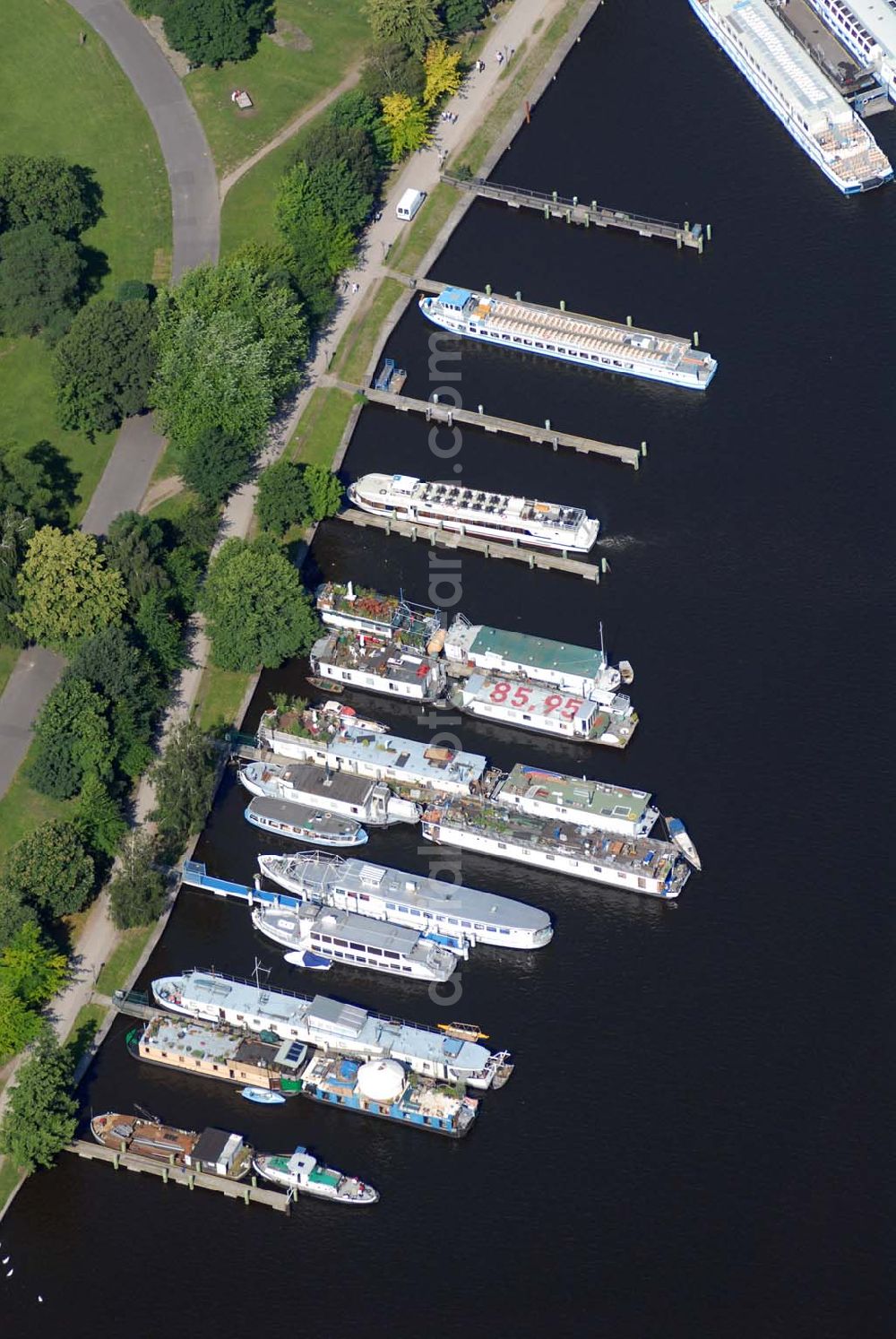 Aerial photograph Berlin - Blick auf den Fahrgastschiffhafen Treptow. Die Stern und Kreisschiffahrt GmbH Berlin ist ein Berliner Schifffahrtunternehmen mit Sitz in Alt-Treptow. Das Unternehmen wurde am 8. August 1888 vom Kaufmann Krokisius aus der Berliner und Stralauer Dampfschiffahrts-Gesellschaft unter dem Namen Spree-Havel-Dampfschiffahrts-Gesellschaft Stern gegründet und fusionierte 1992 mit der Weißen Flotte Berlin. Es betreibt mit heute 30 Fahrgastschiffen den Fähr- und Ausflugsverkehr in und um Berlin und gehört zur Hegemann-Gruppe.