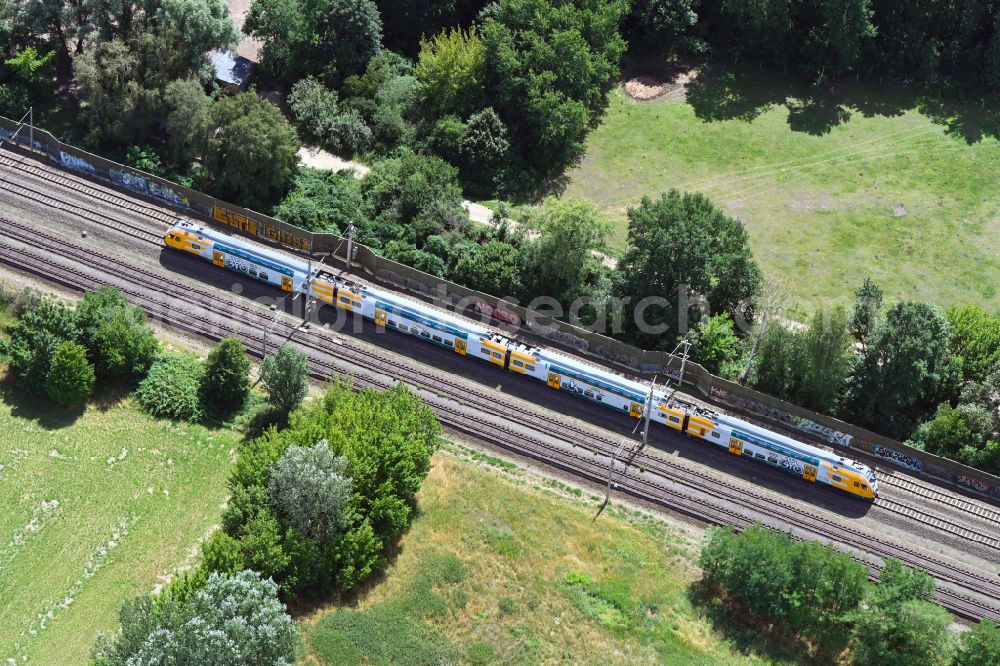 Aerial image Dallgow-Döberitz - Driving a train of the Ostdeutsche Eisenbahn GmbH - ODEG - on the track route in Dallgow-Doeberitz in the state Brandenburg, Germany