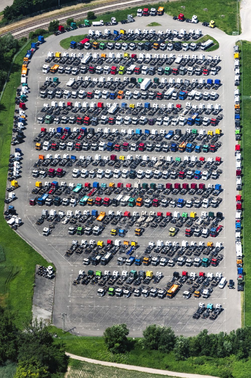 Wörth am Rhein from the bird's eye view: Buildings and production halls on the vehicle construction site and parking spaces for new vehicles in Woerth am Rhein in the state Rhineland-Palatinate, Germany