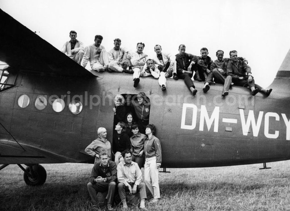 Aerial photograph Magdeburg - Die Fallschirmsprungmannschaft DYNAMO vor einer Antonow AN-2 mit der Kennung DM-WCY auf dem Flugplatz Magdeburg anläßlich der 5. Weltmeisterschaften im Motorkunstflug vom 18. bis 31. August 1968. Von größerer sportpolitischer Bedeutung waren hingegen die beim Ministerium für Staatssicherheit (MfS) angesiedelten Fallschirmspringer des SC Dynamo Hoppegarten, die sich dank einer großzügigen Förderung und professioneller Trainingsbedingungen erfolgreich im internationalen Wettkampfgeschehen etablieren konnten und viele Weltmeistertitel erwarben.