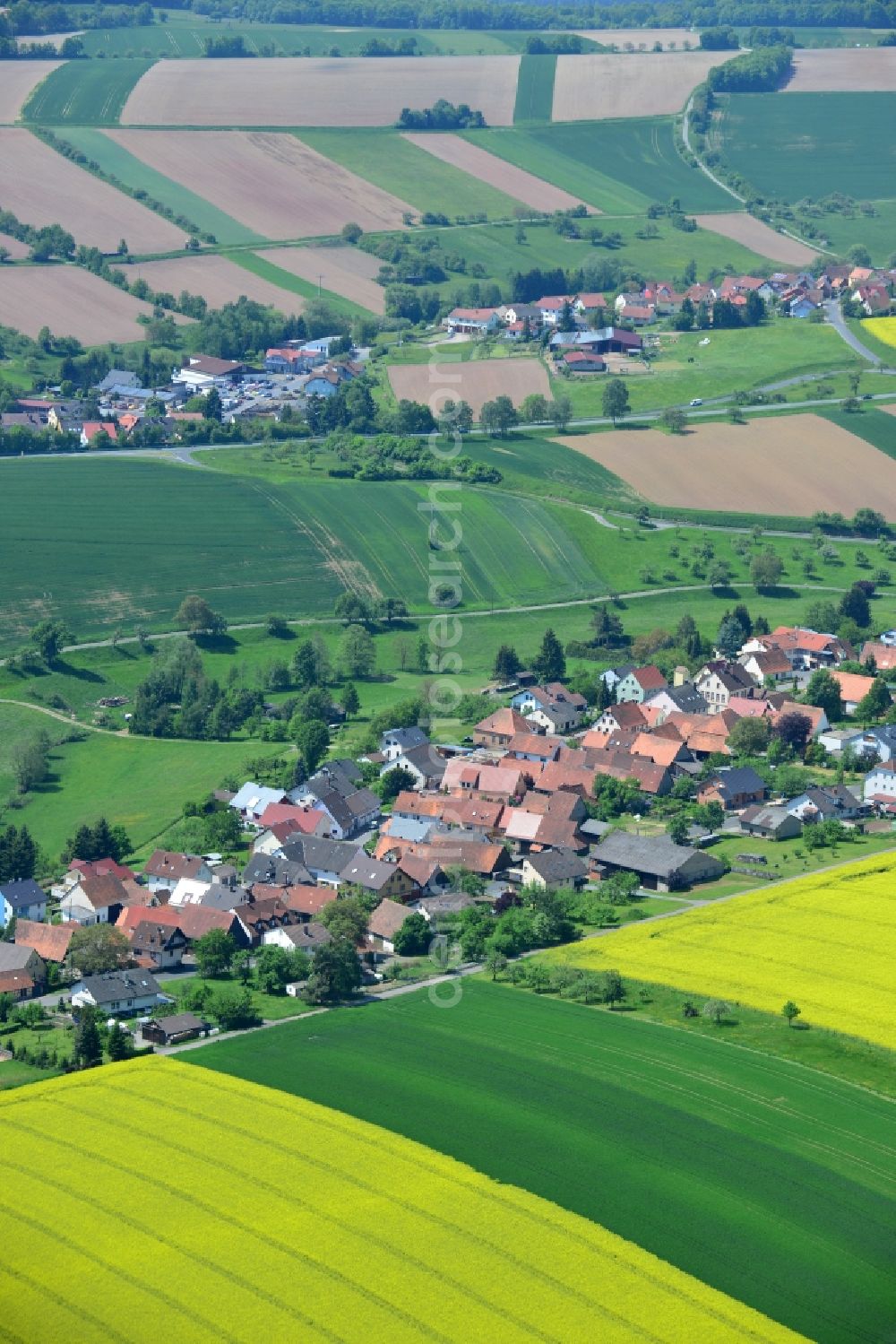 Karbach from the bird's eye view: Field landscape yellow flowering rapeseed flowers in Karbach in the state Bavaria