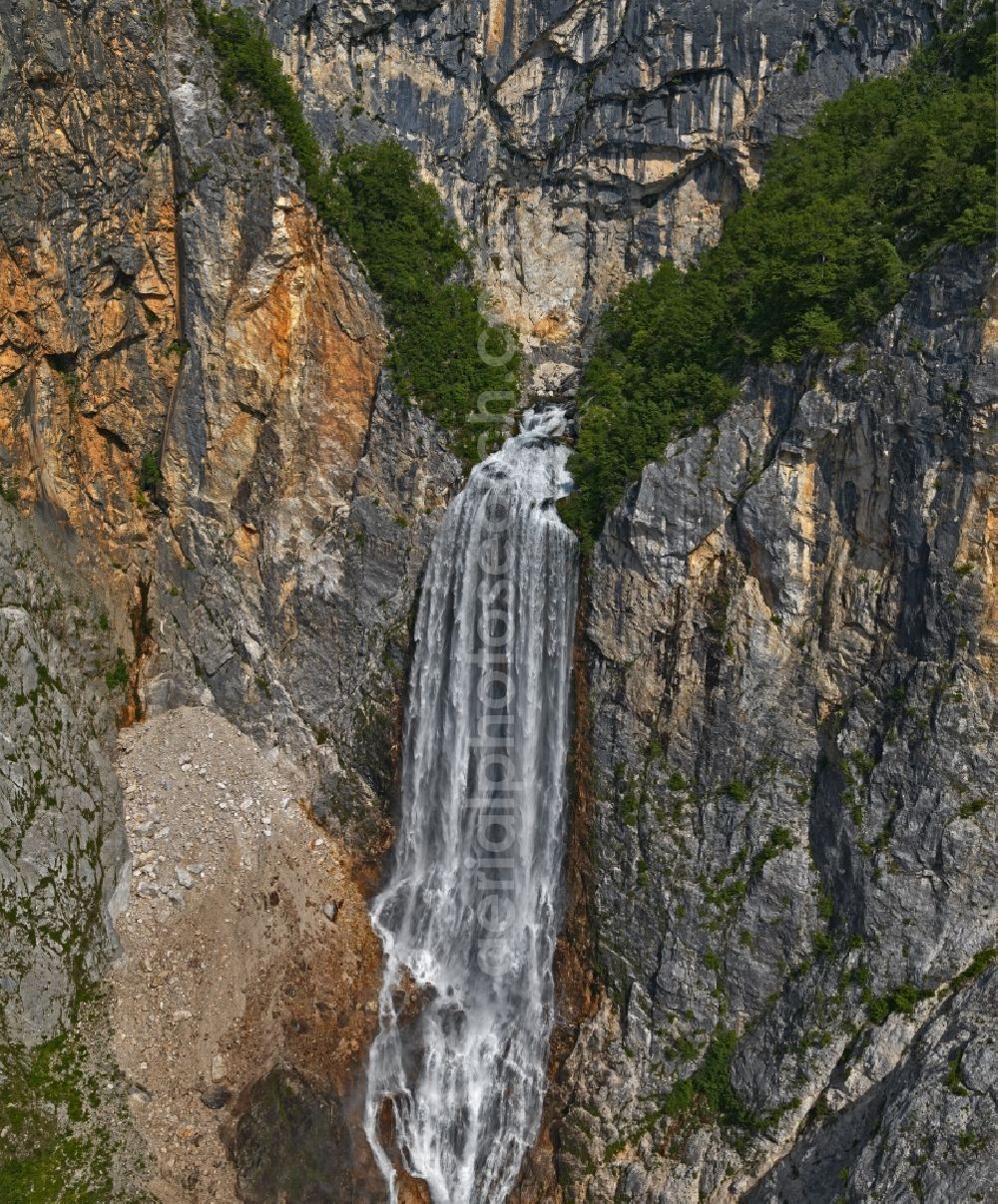 Bovec from above - Rock and mountain landscape near Boka waterfall in Bovec in Tolmin, Slovenia.The Boca waterfall carves its way into the limestone cliff. 100 cubic metres of water per second plunge 144 metres into the depth when the snow melts in the mountains above