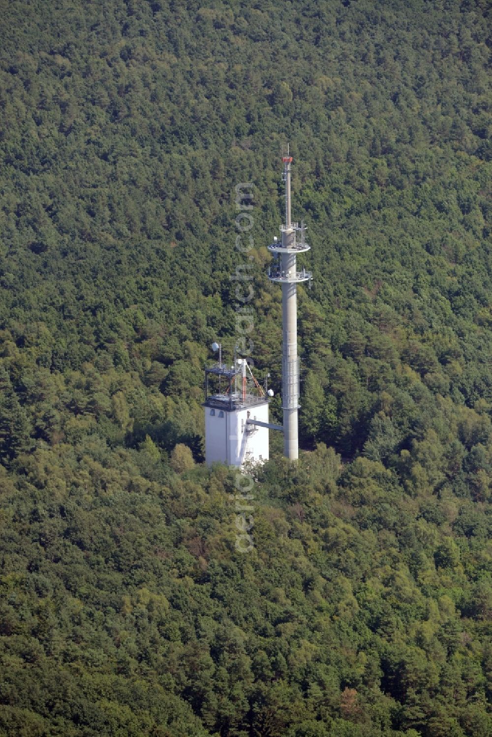 Aerial image Rauen - Transmission tower radio mast of German Funkturm in the Mountains of Rauen in Rauen in the state of Brandenburg. An outbuilding with antenna stands adjacent to the actual tower. The compound is located amidst a forest