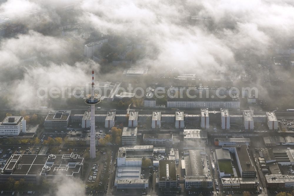 Essen from the bird's eye view: View of the area around the telecommunication tower and ETEC shrouded by fog patches and autumn weather clouds in the state North Rhine-Westphalia. The top of the television tower breaks through an impressive cloud cover over the Holsterhausen district in the Ruhr region city